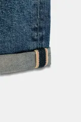 Pantalón de jeans estilo relaxed fit, de tiro alto, color azul con efecto lavado y botamanga con vuelta. Cuenta con cinco bolsillos, trabillas para cinto y cierre frontal con cremallera y botón metálico.