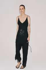 Pantalón satinado Zara Woman Collection, confeccionado en viscosa, de tiro medio y cintura elástica. Presenta diseño de pernera recta con delicados bordados a tono en los bajos.