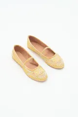 Bailarina negra de estilo plano con tira de terciopelo que cruza el empeine. Presenta bordados intrincados en hilo dorado y apliques de lentejuelas y cuentas en la punta y el cuerpo del zapato.