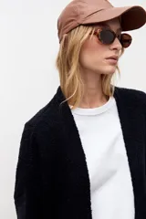 Cardigan de punto color negro, con diseño abierto sin botones, mangas largas con puños ajustados y corte holgado.