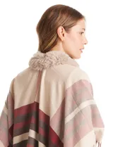 Ruana tejida con diseño a cuadros en tonos beige, rojo y marrón. Presenta un cuello con aplique de piel sintética y terminación en flecos en los bordes.