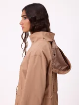 Rompevientos negro con capucha ajustable mediante cordones, cierre frontal de cremallera y ajuste en la cintura con cordón. Presenta logo de la marca bordado en el pecho y puños con detalle de botón.