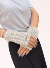 Guantes sin dedos tejidos en punto trenzado color gris claro con hilos plateados brillantes. Presentan una etiqueta metálica decorativa en el dorso.