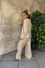 Canguro holgado color beige, con capucha y bolsillo canguro frontal.