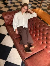 Zueco de cuero color chocolate con diseño cerrado en la parte frontal y suela de goma con plataforma baja.