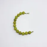 Pulsera de cuentas esféricas de jade limón de 10 mm, con separadores de hilo verde y cierre de mosquetón con baño de oro.