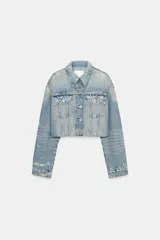 Cazadora de denim crop con cuello solapa, manga larga y cierre frontal con botones. Presenta efecto lavado, bolsillos de plastrón con solapa en el pecho y detalles de rotos.