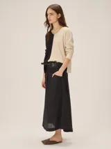 Buzo de tejido de punto bicolor con diseño dividido en negro y beige, cuello en V y mangas largas.