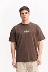 Remera oversize de algodón color marrón, de corte amplio y relajado, con estampa en el frente.