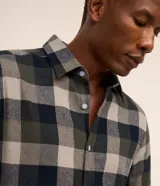Camisa de franela para hombre, modelo comfort, con estampado de cuadros en tonos azules, blancos y negros, cuello camisero, manga larga y cierre frontal de botones.