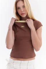 Top de canalé amarillo con cuello redondo y ribetes en color bordo, mangas cortas y detalle de logo bordado en el pecho.