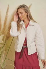 Campera matelasse impermeable color crudo, con cierre frontal, cuello y puños de pana. Presenta bolsillos frontales con solapa y botón.