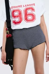 Remera oversize gris oscuro con cuello en V y mangas cortas. Presenta una estampa frontal estilo universitario con el número "09" y las inscripciones "MVD", "UY" y "PIMENTÓN ACTIVE" en tonos celestes y blancos.