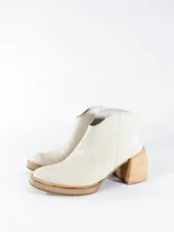 Botas cortas color crema con textura simil cuero de reptil, con cierre lateral y taco de madera.