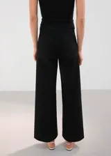 Jeans estilo cargo color negro de corte recto y tiro medio, con bolsillos aplicados en el frente.