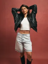 Short tipo bermuda de jean en color azul claro con lavado ácido, de corte holgado y largo hasta la rodilla con ruedo doblado.