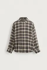 Camisa de corte relajado con diseño de cuadros en tonos negro y beige, cuello camisero, manga larga y cierre frontal de botones.