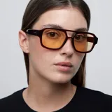 Lentes de sol de aviador oversize con montura marrón y lentes amarillas.