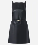 Vestido corto evasé negro de poliuretano con breteles finos y cinturón con hebilla metálica.