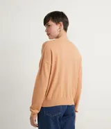 Buzo de punto color verde lima, con cuello redondo, manga larga y diseño de sisa desplazada.
