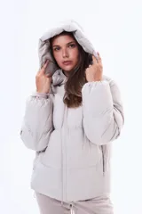 Campera puffer de corte holgado en color beige, con capucha integrada, cierre frontal completo y bolsillos laterales. Presenta un diseño acolchado con acabado mate y puños elásticos.