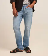 Pantalón de jean para hombre, modelo slim con lavado claro, trabillas en la cintura y bolsillos delanteros y traseros.