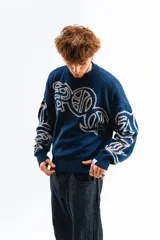 Sweater tejido reversible con cuello alto, puños y ruedo acanalados. Un lado es azul marino con diseño de letras en blanco y el otro lado es gris con diseño de letras en azul marino. Corte BoxyFit/RegularFit.