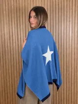 Ruana tejida de algodón en color marrón con detalles en off-white, destacando un diseño de estrella grande en la espalda y bordes en contraste.