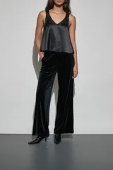 Pantalon de vestir negro de corte recto y tiro alto, confeccionado en tela de terciopelo con acabado brillante.