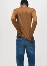 Sweater de punto fino color mostaza, con cuello alto y mangas largas de diseño recto.