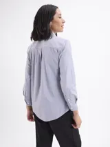 Camisa de corte clásico con estampado de rayas verticales finas en color azul y blanco, cuello camisero y cierre frontal con botones.