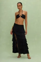 Falda maxi negra de mujer en lycra con volados que recorren la silueta y crean un juego de volumen y movimiento.