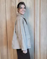 Sobrecamisa de paño color beige, con cuello solapa, cierre frontal de botones y dos bolsillos delanteros con solapa.