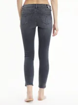Jeans de mezclilla gris oscuro lavado, corte skinny y talle medio, con una banda lateral vertical que lleva el texto "Calvin Klein Jeans" repetido.