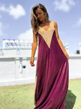 Vestido largo de corte holgado con diseño bicolor en tonos bordó y dorado, confeccionado en tela satinada con acabado brillante. Presenta escote en V y breteles anchos.