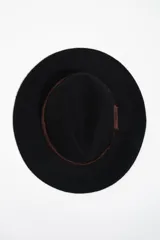 Sombrero de ala ancha confeccionado en lana negra, con cinta decorativa de grosgrain en color marrón oscuro con bordes deshilachados.