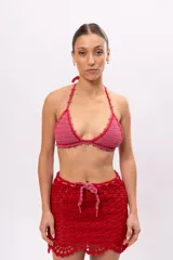 Top de bikini tejido a crochet color rosa con terminaciones en rojo y tirantes finos.
