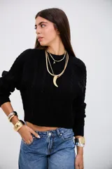 Sweater negro de tejido de punto con diseño de trenzas verticales, cuello redondo y corte cropped.