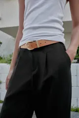 Pantalón tobillero azul marino de tiro medio, con pinzas delanteras, bolsillos frontales, falsos bolsillos con solapa en la espalda y cierre frontal con cremallera, botón y gancho. Incluye cinturón de cuero sintético tostado con hebilla metálica dorada.