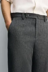 Pantalón de corte carrot fit confeccionado en tejido con mezcla de viscosa. Presenta bolsillos frontales, bolsillos traseros de vivo y cierre frontal con cremallera y botones.