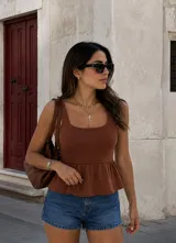 Top de punto color marrón chocolate, sin mangas, con escote cuadrado y diseño peplum con vuelo en la cintura.