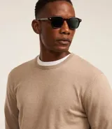 Suéter de punto color borgoña, con cuello redondo, sisas ligeramente desplazadas y bajo y puños acanalados.