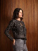 Saco de punto con estampado animal print, de corte recto y manga larga. Presenta cierre frontal mediante lazos ajustables y terminaciones en tejido acanalado.