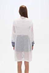 Saco largo de acrílico tejido a crochet, con diseño de rayas horizontales en tonos blanco, azul y negro.