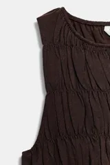 Top sin mangas de color marrón, con cuello redondo y diseño completamente fruncido con elásticos y un sutil volante en el bajo.