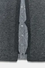 Chaqueta de punto con diseño de doble capa, cuello redondo y manga larga. Presenta una capa exterior gris oscuro y una capa interior gris claro con estampado de rombos, ambas con cierre frontal de botones.