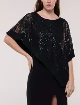 Vestido largo azul marino de seda fría, compuesto por una falda recta con tajo frontal y una capa superior superpuesta de encaje con lentejuelas bordadas, escote a la base y mangas tres cuartos acampanadas.