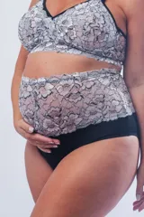 Bombacha maternal de tiro alto confeccionada en algodón elastizado negro, con una faja superior de puntilla bicolor en blanco y negro.