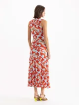 Vestido midi sin mangas con estampado floral en tonos rojos y celestes, cuello alto y detalle fruncido en el centro delantero.