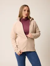 Campera de polar color beige, con cierre frontal completo, cuello alto y bolsillos laterales con cierre.